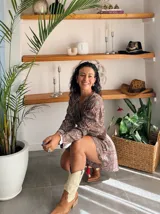 Conjunto de dos piezas estampado, compuesto por un top cruzado de manga larga acampanada y un short a juego. El estampado es de estilo paisley en tonos turquesa y marrón.