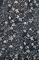 Top negro con estampado floral blanco, breteles finos y escote en V.