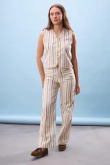 Pantalón de vestir de corte recto, color beige con rayas verticales marrones, celestes y rosas.