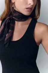 Musculosa tejida en punto rib, color negro, con hilado de viscosa y detalles de lurex, de escote redondo y calce al cuerpo.
