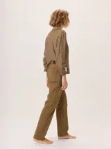 Jean recto de gabardina color marrón/camel, con pespuntes contrastantes en color negro. Presenta un detalle de atraque rojo en el bolsillo trasero.