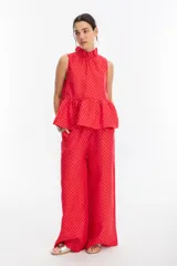 Pantalón de lino rojo con print plateado, con cintura elástica, bolsillos laterales y piernas anchas.