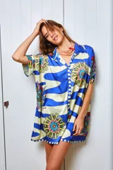 Camisola estampada en seda, con cuello camisero, manga corta y calce holgado. Presenta un diseño con rayas horizontales y flores. Puede usarse como camisa o vestido.
