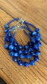 Collar corto de cuentas facetadas de color azul con cuentas más pequeñas entre las grandes.