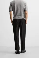 Pantalón color arena de corte recto, confeccionado en tejido elástico. Cuenta con cintura elástica ajustable con cordón, bolsillos laterales y bolsillos de vivo en la parte trasera.
