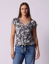 Blusa de modal con estampado de hojas en tonos azulados, escote en V con botones y ruedo anudado.