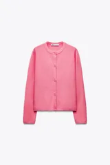 Chaqueta de punto rosa con cuello redondo y manga larga. Cierre frontal con botones.