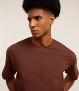 Remera marrón de corte boxy, cuello redondo y manga corta.