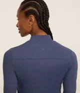 Campera deportiva negra confeccionada en poliamida y elastano, con cuello alto, cierre delantero por cremallera y bolsillos laterales.