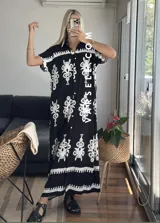 Vestido camisero largo negro con estampado de flores blancas y cinto incluido.