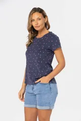 Remera de manga corta color gris claro con estampado de pequeñas figuras geométricas en azul.