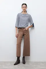 Buzo de cuello redondo con estampado de rayas horizontales blancas y azul marino. Presenta mangas de largo 3/4 con un panel lateral en contraste, botones decorativos y terminación en volados.