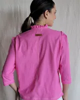 Camisa blanca de mangas 3/4 con cuello mao y botones frontales.