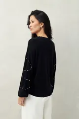 Sweater color beige con cuello redondo y mangas largas. Decorado con perlas sintéticas en forma de rombos.