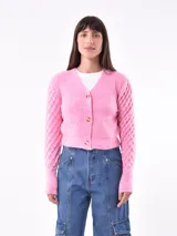 Cárdigan tejido color rosa con cuello en V, manga larga y cierre frontal con botones dorados.
