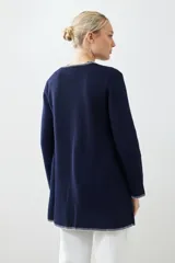 Saco tejido azul marino con pespuntes blancos en cuello, solapa, borde y puños.