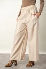 Pantalón palazzo de viscosa y lino color beige claro satinado, con cintura elastizada y bolsillos laterales.