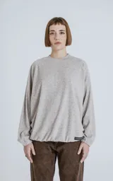 Sweater beige de corte holgado, cuello redondo y mangas largas con puños elásticos.