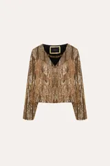 Saco corto dorado con flecos, bordado con lentejuelas y detalles en canutillo, con escote en V y mangas largas.