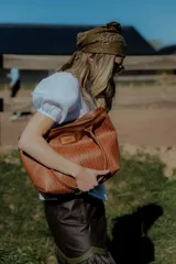 Bolso tipo tote de cuero color marrón con diseño tejido. Tiene bolsillo interno, porta llaves y cierre.