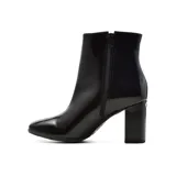 Bota corta de charol negro con taco cuadrado y punta redondeada.