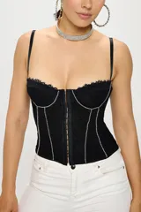 Top corset negro de encaje con breteles finos regulables, cierre frontal con ganchos y detalle de strass en el borde superior y en las costuras verticales.