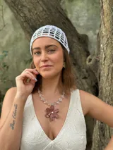 Collar corto con cuentas de cristal transparente y dije de flor color marrón.