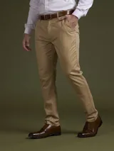 Pantalón de vestir color azul marino, de corte slim fit, con bolsillos laterales y traseros. Se ajusta a la cintura con cinturón de cuero marrón.