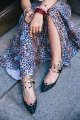 Botines bajos negros con diseño tejido y cordones con borlas. Presentan detalles de animal print en el tobillo y ribete ocre.