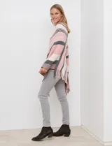 Poncho de tejido de punto color beige y salmón con diseño de rayas diagonales y cuello en V. Presenta terminación con flecos en el ruedo.