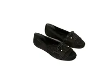 Mocasín de cuero gamuzado color negro, con flecos y lazo con herrajes metálicos dorados. Interior forrado en cuero y suela de goma flexible.
