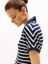 Vestido corto de corte evasé a rayas horizontales azul marino y blancas, con cuello tipo chomba azul marino y mangas cortas.