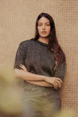 Sweater color dorado de tejido de punto suave con hilos metalizados, corte recto y mangas cortas con puño ajustado.