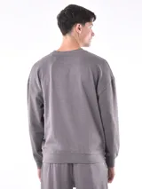 Buzo gris de corte holgado con cuello redondo y mangas largas.