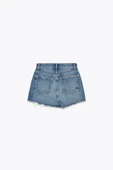 Minifalda de denim azul con tiro medio, trabillas, cinco bolsillos, roturas y bajo desflecado.