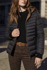 Campera acolchada negra con costuras horizontales, forro y capucha en color marrón claro. Cierre frontal y puños de tejido acanalado.