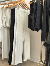 Pantalón blanco de vestir con finas rayas verticales, corte recto y tiro alto.