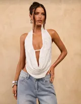 Top blanco con lentejuelas, escote halter y espalda descubierta.