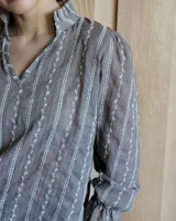 Blusa celeste con cuello mao y mangas abullonadas.