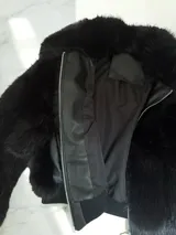 Campera corta de piel sintética negra con cierre metálico plateado.