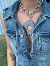 Collar plateado con cadena de eslabones grandes y dije abstracto desmontable de acrílico y resina color gris.