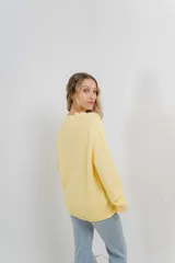 Sweater azul de punto medio, amplio, suave, con escote a la base y puños en mangas y en acabado inferior.