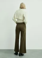 Pantalón de pana color marrón, de corte culotte y tiro alto, con cierre de cremallera y botón, trabillas, dos bolsillos de parche delanteros y dos bolsillos de parche traseros.