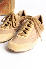 Zapatillas deportivas verde oliva con cordones y suela marrón.