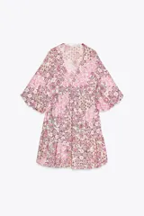 Vestido corto con estampado floral en tonos rosados, escote en pico y mangas abullonadas.