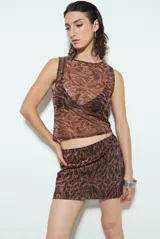 Minifalda ajustada con estampado animal print en tonos marrones y negros, con acabado brillante.