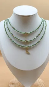 Set de tres collares de cristalitos facetados color verde, con detalles dorados y dije de estrella y luna en baño de oro y circonitas.