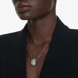 Colgante con cadena de eslabones color negro y dije abovedado con cristales de distintos tamaños en tonos azules y verdes.