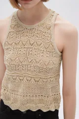 Musculosa de tejido crochet color beige con cuello redondo y sisas con terminación acanalada.