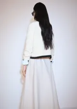 Sweater de punto grueso color crema con cuello alto con cierre de cremallera y detalle de rayas marrones en contraste en mangas y ruedo.